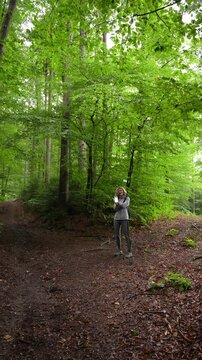 Woman Using Modern Hiking App While Walking on Forest Trail