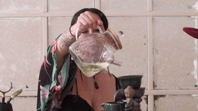 Pouring water. Aesthetic relaxation. Woman filling bowl with puer tea enjoying meditation aromatherapy smoke spiritual practice mind tranquility.