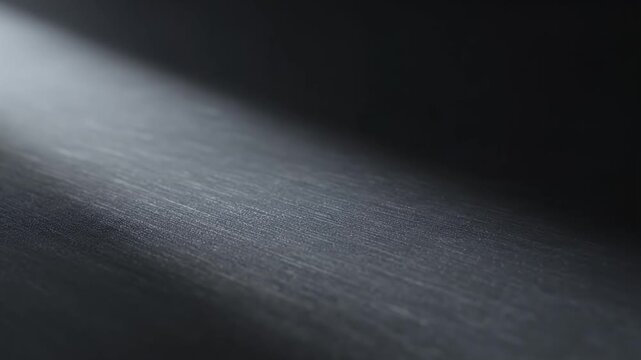 Abstract dark background with a diagonal beam of light creating a dramatic spotlight effect