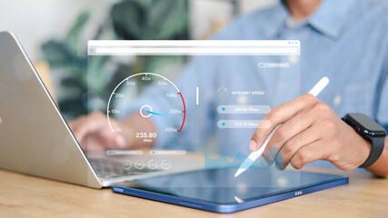 A person testing high speed internet connection on a digital tablet and laptop at home office,...