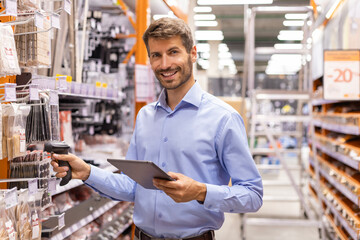 Fototapeta premium Warehouse worker scan goods in inventory in a hardware store and check stock product on digital tablet