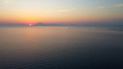 Obraz premium Aerial sunset over Kyllini coast Greece with view towards Zakynthos and Kefalonia, golden hour seascape, Ionian Sea islands, dramatic sky, summer travel destination, drone photography, Mediterranean 