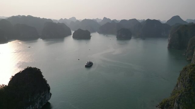 Aerial view of limestone karst mountains and cruise ships navigating the waters of Ha Long Bay near Cat Ba Island, Vietnam.