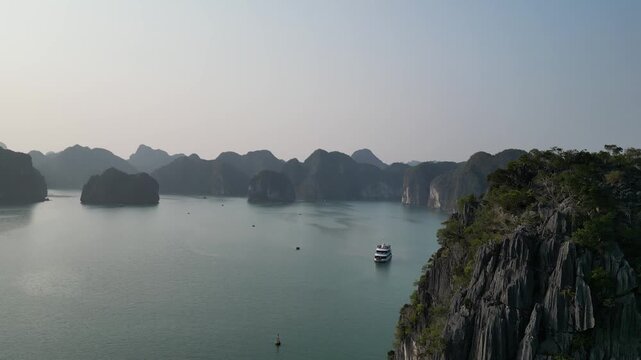 Aerial view of limestone karst mountains and cruise ships navigating the waters of Ha Long Bay near Cat Ba Island, Vietnam.