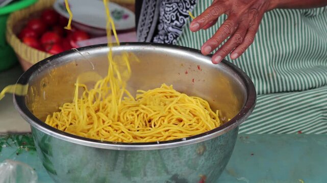 Indonesian egg noodles inside stainless steel bowl for street food preparation with natural light