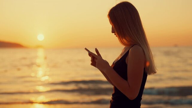 Young woman surfing internet by modern smartphone on sea shore, medium portrait. Internet addiction and social media overuse, female mobile phone user testing new application, roaming in summer trip
