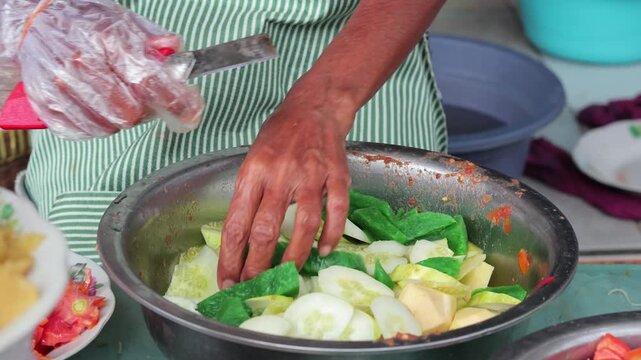 Indonesian street food vendor cutting green jelly snack with natural light for culinary concept