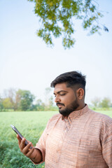 Fototapeta premium indian farmer using smartphone at agriculture field