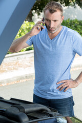 Obraz premium man with broken down car calling somebody for help