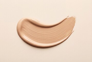 Fototapeta premium Creamy beige liquid foundation smear with smooth texture isolated on a light nude background surface