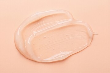 Transparent peach tinted gel smear with glossy brushstroke texture