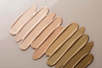 Obraz premium Gradient texture of liquid foundation cream in diagonal strokes showing multiple skin tone shades