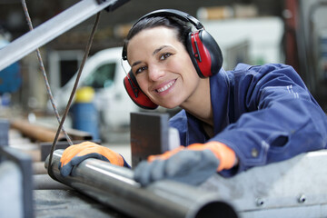 happy woman laborer is ready to cut pipes
