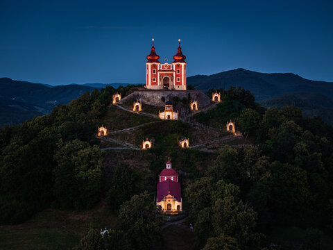 Banska Stiavnica, Slovakia - Aerial view of the beautiful illuminated Baroque Calvary in Slovakia at dusk on a summer afternoon with clear blue sky