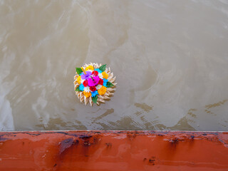 Pre-Eulogy Offering: Vibrant Krathong Floating by the Riverboat