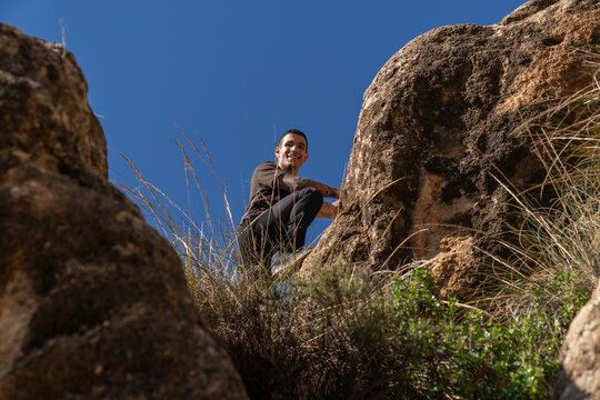 Man bouldering outdoors on rocks enjoying nature