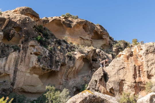 Man bouldering on sandstone rocks in desert landscape