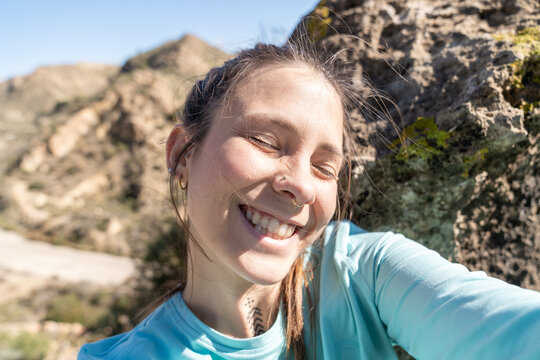 Young woman enjoying sunshine taking outdoor selfie