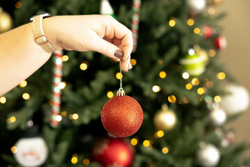 Naklejka premium Woman decorating a Christmas tree