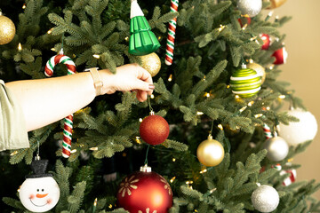 Naklejka premium Woman decorating a Christmas tree