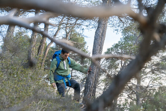 Man hiking through forest trail with backpack