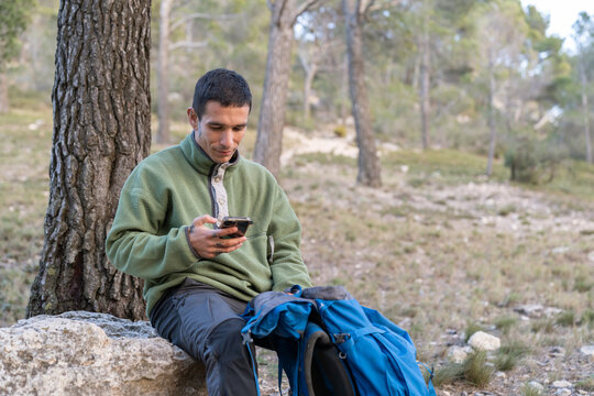 Hiker connecting with smartphone in nature