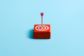 Red arrow hits a target circle on red wooden cube. Market research. Bulls-eye. Marketing. High advertising efficiency.