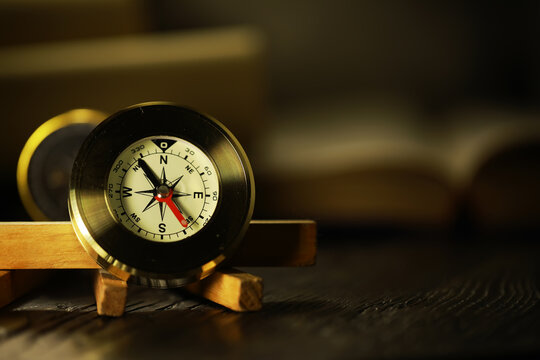 Antique Brass Compass on Wooden Stand with Blurred Background