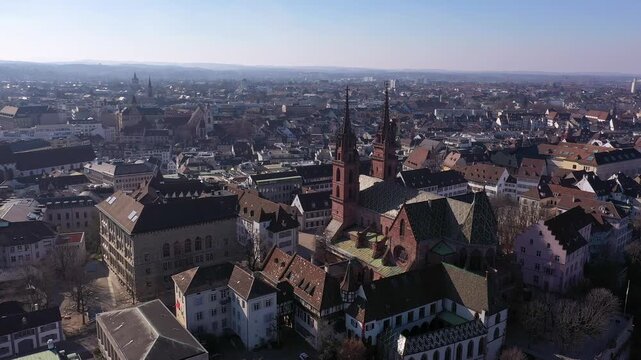 Basel, Switzerland: Aerial drone footage of Basel old town with the Basler Munster, the gothic cathedral, along the Rhine river in Switzerland on a sunny winter day. Shot with a tilt down motion