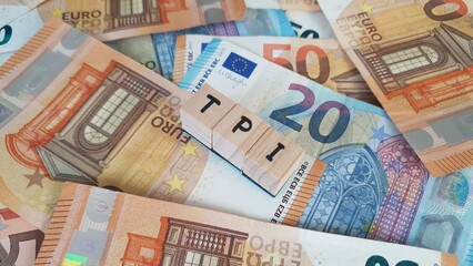 Fototapeta premium TPI acronym made of wooden letter cubes on pile of Euro banknotes. Toekomst Pensioen Instelling (Future Pension Institution)