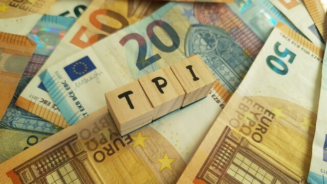 TPI acronym made of wooden letter cubes on pile of Euro banknotes. Toekomst Pensioen Instelling (Future Pension Institution)