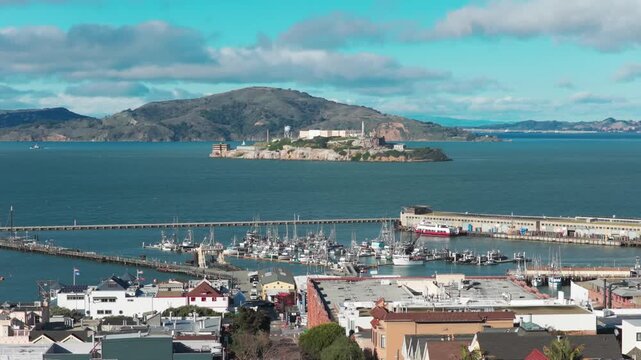 Wide panning aerial shot the San Francisco National Maritime Historical Park at Fisherman's Wharf with Alcatraz Island in the distance in Northern California. 4K