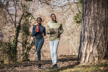 Happy couple running outdoors on a nature trail