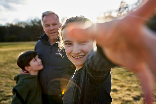 Portrait of happy girl with her family on a meadow