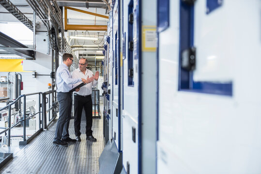 Two men talking in factory shop floor