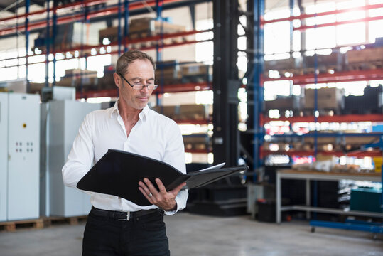 Man with documents on factory shop floor
