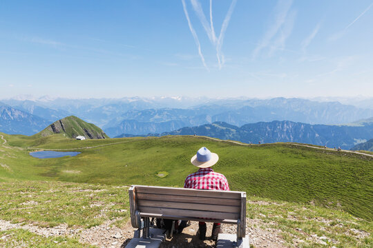 Switzerland, St Gallen Canton, Man resting on bench, looking on the mountains