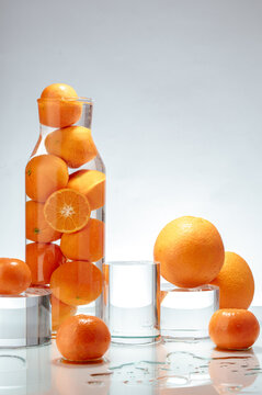 oranges and tangerines in a glass vessel and on a table.