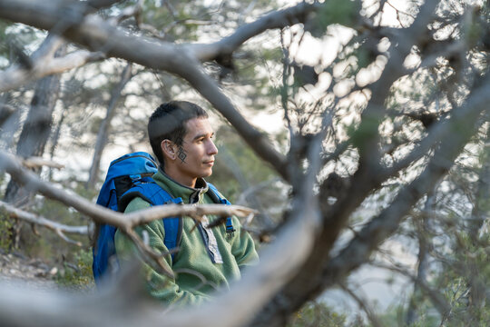 Young man hiking in nature contemplating scenic view