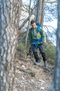 Man with backpack hiking down mountain trail