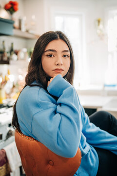 Young woman sitting in kitchen thinking about future