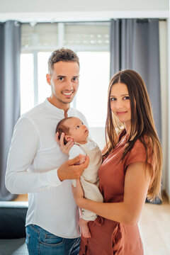 Happy parents carrying baby boy at home