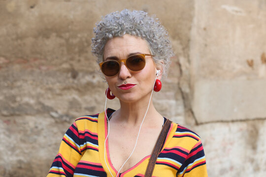 Portrait of pierced mature woman with ear phones