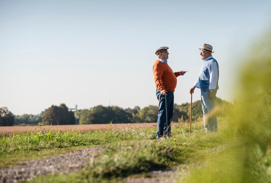 Two old friends standing in the fields, talking about old times