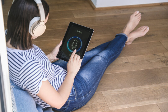 Young woman with tablet awith smart home control functions and headphones