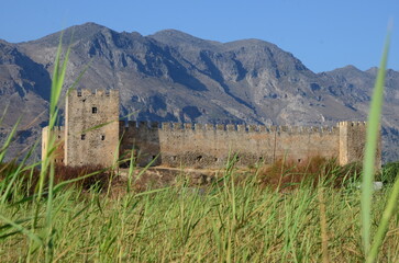 Frangokastello fort in Crete island through the grass, mountains in the back