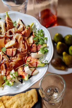 Close up texture of fig and prosciutto salad with balsamic glaze. Appetizing gourmet food background.