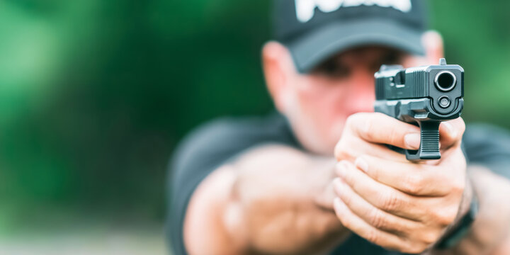 Police officer aiming handgun during firearm training, focusing on target acquisition and self defense skills