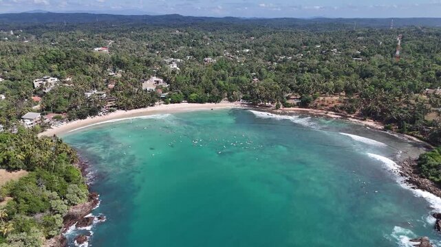 Drone view of tropical beach cove surrounded by jungle and hills, Sri Lanka, Hiriketiya, Dikwella