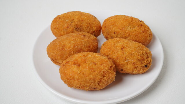 A snack called combro, typical of West Java, Indonesia, made from cassava with oncom chili sauce filling, served on a white plate and placed in a white place (isolated white).